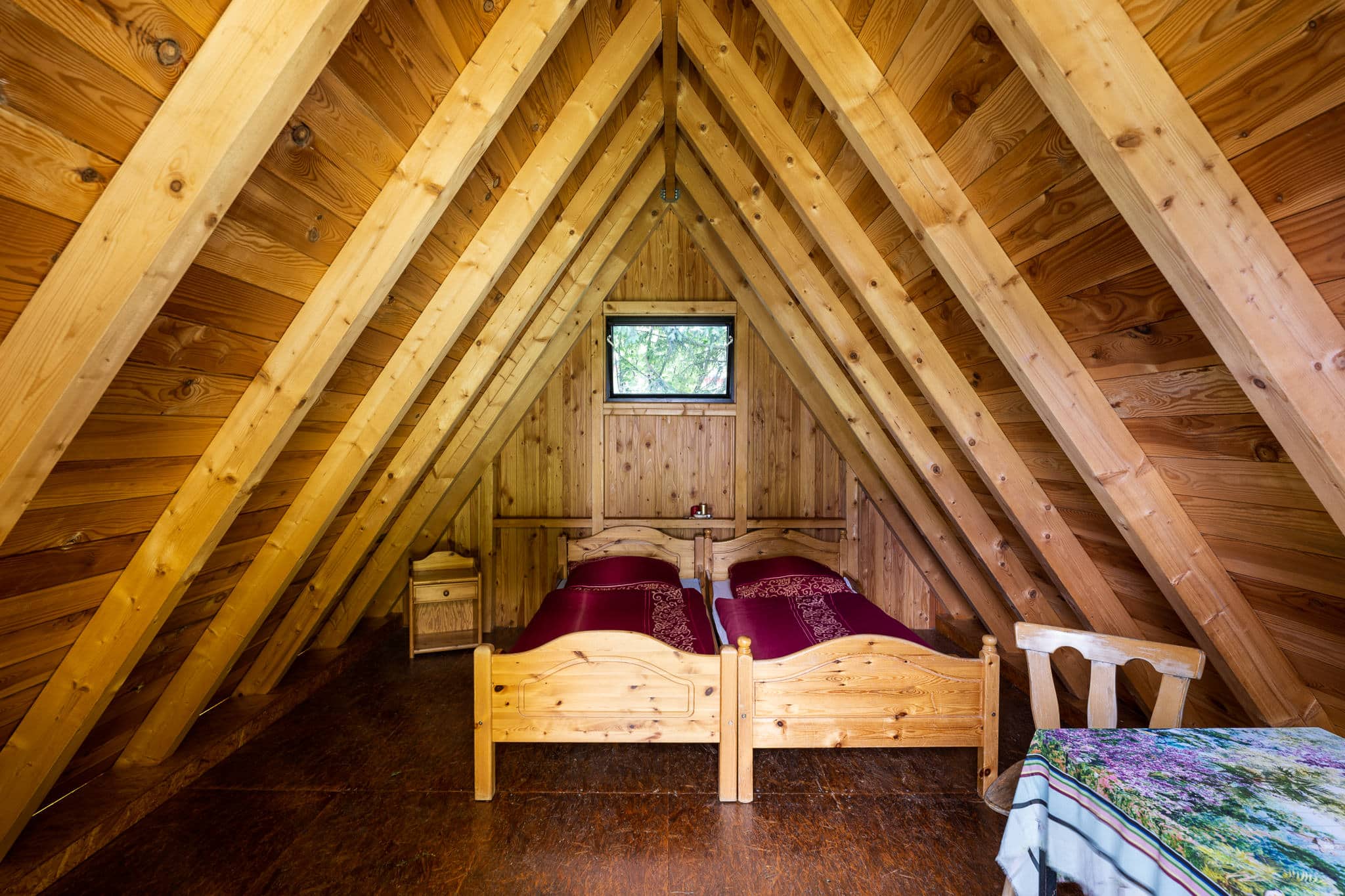 Gemütliches Schlafzimmer im hölzernen Dachboden mit Betten
