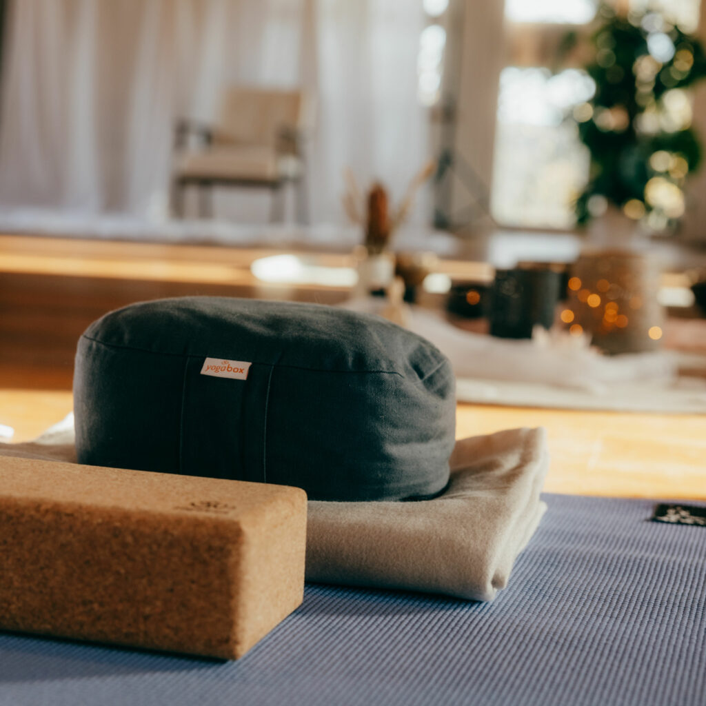 Yogamatte mit Meditationskissen und Yoga-Block im Studio